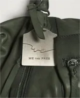 Cartera de cuero color negro con efecto lavado y desgastado, estilo vintage. Cuenta con múltiples bolsillos con cierre delantero, tiras colgantes y doble asa corta de mano.