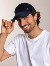 Gorra de pana color camel con visera curva y logo bordado en el lateral.