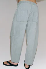 Pantalón de tiro medio confeccionado en hilatura con mezcla de algodón, con diseño de rayas diplomáticas. Presenta bolsillos laterales ocultos en costura, pierna ancha y cierre frontal con cremallera y botón.