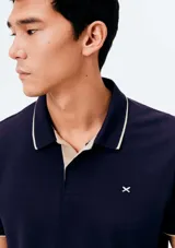 Chomba negra de manga corta con cuello camisero, cartera de botones y detalle bordado en el pecho.