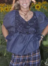 Camisa de color azul oscuro con mangas abullonadas y panel frontal de encaje floral a tono con cierre de botones.