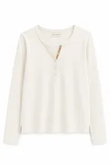 Remera de algodón con spandex, color negro, de manga larga y ajuste al cuerpo. Presenta un escote redondo con cartera frontal de botones y detalle de cordón decorativo en contratono.