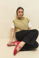 Chaleco tejido a rayas horizontales color verde oliva y beige, sin mangas y con cuello redondo.