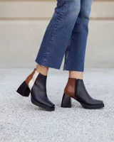 Botinetas de cuero con diseño tricolor en negro, marrón con textura croco y blanco. Presentan taco cuadrado, plataforma y cierre lateral.