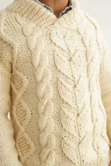 Sweater de lana color beige, tejido a mano con ochos y cuello cruzado. Terminaciones en punto elástico en puños y ruedos.