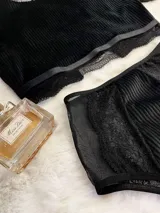 Conjunto de lencería compuesto por un top de cuello alto con mangas cortas y una bombacha de tiro alto. Ambas piezas combinan paneles de terciopelo, microtul transparente y detalles de encaje elastizado.