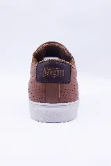 Championes de cuero color marrón con diseño perforado en los laterales, cordones al tono y suela de goma blanca.