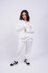 Pantalón de jogging color beige con cintura elástica y logo estampado en blanco en el muslo.