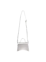 Cartera tipo bandolera pequeña, color plateado metalizado, con solapa superpuesta y correa fina ajustable.