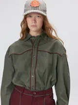 Camisa western de algodón grueso color verde militar, con corte holgado y aplicaciones de hilo en contraste en el pecho, la cartera de botones y los puños.