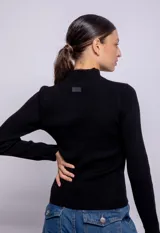 Polera color beige de tejido de punto con cuello alto y mangas largas con detalles calados.