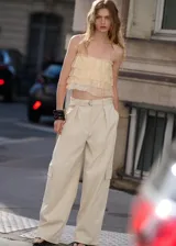 Pantalón cargo de tiro medio en color beige, con diseño recto, bolsillos de parche con solapa en los laterales y detalle de cinturón integrado en la cintura.