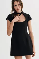 Vestido corto de color negro con escote cuadrado y detalle de lazada en el cuello. Presenta mangas cortas y cierre de cremallera oculta en la espalda.