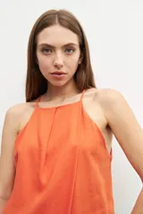 Top halter color naranja de lino con breteles finos y corte holgado.