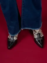 Botas texanas cortas de cuero sintético negro con detalles en animal print y cierre lateral.