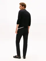 Jean negro Tommy Hilfiger modelo Harlem de corte recto, con cierre de cremallera y botón, diseño de cinco bolsillos, detalles distintivos de la marca y logo bordado en el bolsillo trasero.