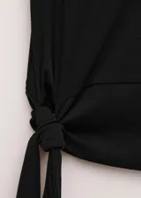 Top negro de algodón con cuello redondo y mangas cortas, con fucsia y detalle de lazo integrado para atar en la cintura.