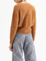 Cardigan de punto color marrón, con cuello redondo, cierre frontal de botones y mangas largas. Presenta un diseño bordado con motivos de cerezas realizados en canutillos.