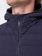 Chaqueta puffer azul marino con capucha, cierre frontal con cremallera y bolsillos laterales.