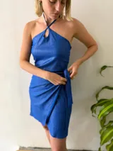 Conjunto de dos piezas color azul brillante, compuesto por un top halter con breteles finos y lazo regulable en el contorno, y una falda corta cruzada regulable.