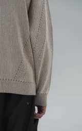 Sweater de punto con diseño de rayas verticales en tonos beige y marrón, cuello redondo y corte oversize.