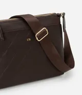 Bandolera femenina confeccionada en material sintético color marrón con efecto embossed, modelo transversal postman con cierre por cremallera, bolsillo externo y asa larga de grosgrain.