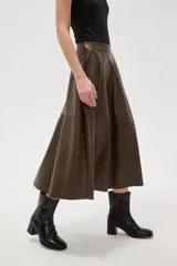 Falda midi de corte acampanado confeccionada en eco-cuero negro, con diseño de paneles y cintura alta.