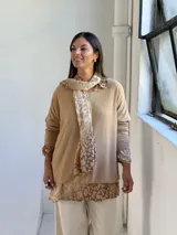 Sweater de punto color arena con diseño de capas que incluye una camisa inferior y un pañuelo a juego, ambos con estampado animal print en tonos tierra.
