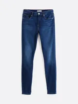 Pantalón jean skinny de tiro medio, color azul oscuro, con efecto desteñido en muslos y rodillas.