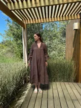 Vestido largo color verde oliva, de lino, con corte amplio, cuello mao, escote en V y mangas largas acampanadas.