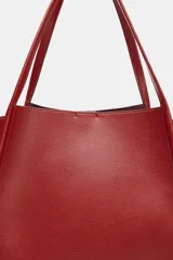 Bolso tipo shopper color rojo de hombro, con detalle de lazos en los laterales y doble asa.
