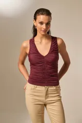 Top sin mangas color bordó, con escote en V profundo y frunces en el frente.