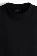 Remera de corte oversized en punto de algodón, con cuello redondo acanalado, hombros caídos y bajo recto.