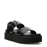 Sandalias de mujer Miss Carol color negro, con base plataforma flatform y suela dentada. Posee dos tiras anchas en el empeine, hebilla metálica grande y tira trasera con velcro.