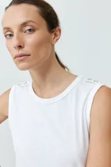 Musculosa de algodón color rojo, con cuello redondo, corte sin mangas y detalle de botones decorativos en los hombros.