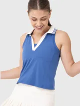 Top deportivo sin mangas con cuello polo y escote en V, diseñado con tecnología de secado rápido. Presenta un diseño bicolor en azul y blanco con detalles de rayas en el cuello.