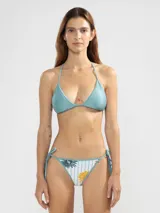 Conjunto de bikini reversible con estampado de rayas y flores. El corpiño es de triángulo con tirantes finos y la bombacha es de corte clásico con lazos laterales.