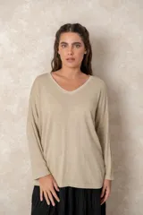 Buzo de punto ligero con acabado metalizado, color beige dorado, con escote en V, mangas largas y corte relajado.