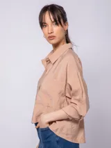 Camisa color verde militar, de manga larga con botones nacarados y doble cartera. Cuenta con un bolsillo delantero y abertura trasera.