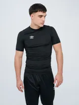Remera térmica deportiva de manga corta de la marca Umbro, color negro, con diseño ajustado y cuello redondo. Presenta el logo de la marca estampado en el pecho en color blanco.