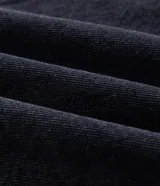 Chaqueta de jean color negro con cuello de sherpa, cierre frontal con botones metálicos, bolsillos con solapa en el pecho y bolsillos laterales. Diseño de corte regular y manga larga.