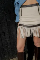 Minifalda color crema de cuero ovino con flecos y detalles en cuero marrón. Cierre frontal con cremallera. Estilo country.