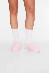 Pantuflas abiertas color rosa con textura de peluche.