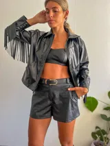 Campera negra de cuero sintético con cierre frontal, cuello clásico y flecos en las mangas.