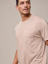 Remera básica de cuello redondo con bolsillo frontal, confeccionada en algodón con efecto de lavado gastado.