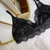 Set de lencería de cuatro piezas compuesto por bralette de encaje, tanga regulable, portaligas y liga para pierna. Diseño con detalles de tiras elásticas y encaje.