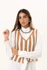 Chaleco tejido a rayas beige y blanco, con escote en V y cierre con ganchitos.