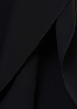 Vestido corto negro de tejido fluido con diseño evasé, cuello alto y mangas cortas asimétricas con volantes.