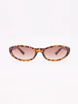 Lentes de sol con montura de carey y forma ovalada, con lentes marrones degradadas.