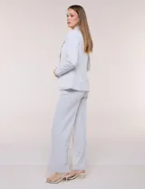 Blazer de sastre entallado color gris claro, con solapa de muesca clásica, cierre frontal de un solo botón y bolsillos frontales de vivo horizontales.